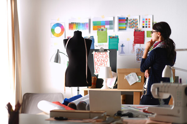 Beautiful fashion designer standing in studio