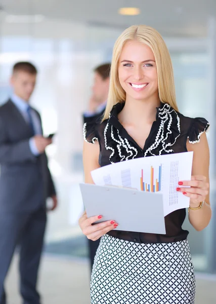 Young businesswoman holding a laptop, standing on office — Stock Photo, Image