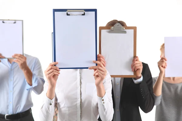 Team of businesspeople holding a folders near face isolated on white background — Stock Photo, Image