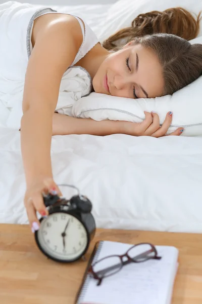 Młoda kobieta odkładająca rano budzik — Zdjęcie stockowe