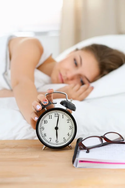 Eine junge Frau stellt morgens ihren Wecker aus — Stockfoto