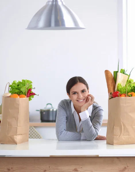 Retrato de uma mulher sorrindo cozinhar em sua cozinha sentado — Fotografia de Stock