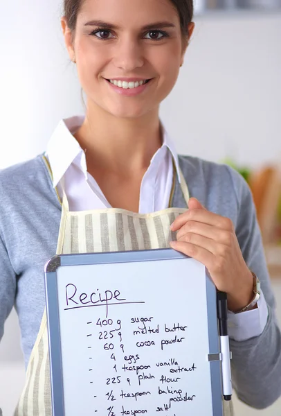 Kvinna i köket hemma, stående nära skrivbord med mapp — Stockfoto