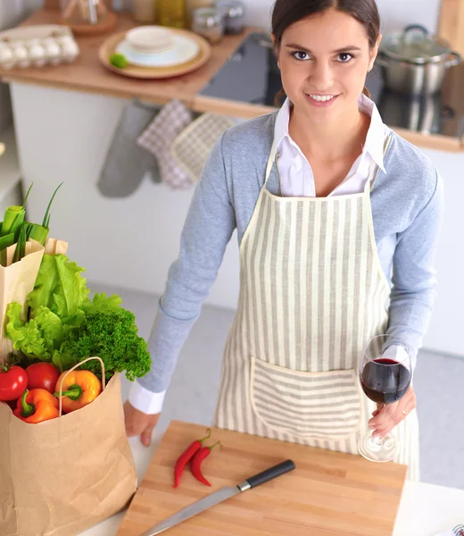 Mujer haciendo comida saludable de pie sonriendo en la cocina —  Fotos de Stock