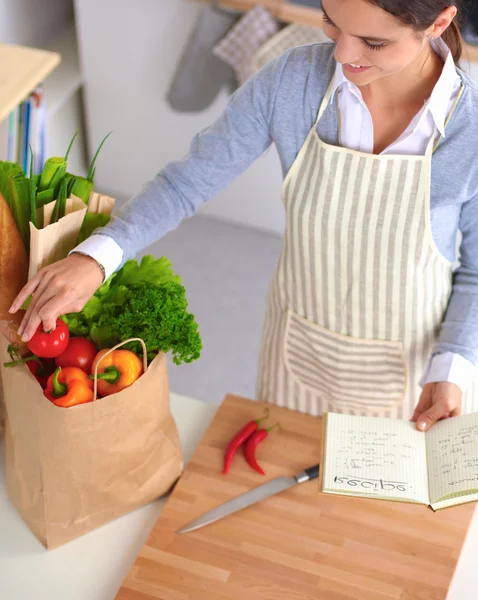 Mujer haciendo comida saludable de pie sonriendo en la cocina — Foto de Stock