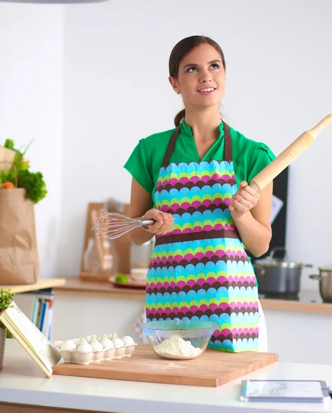 Tersenyum wanita muda di dapur, terisolasi di latar belakang — Stok Foto