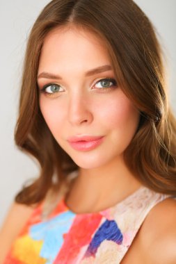 Beyaz arka planda poz veren güzel bir kadın.