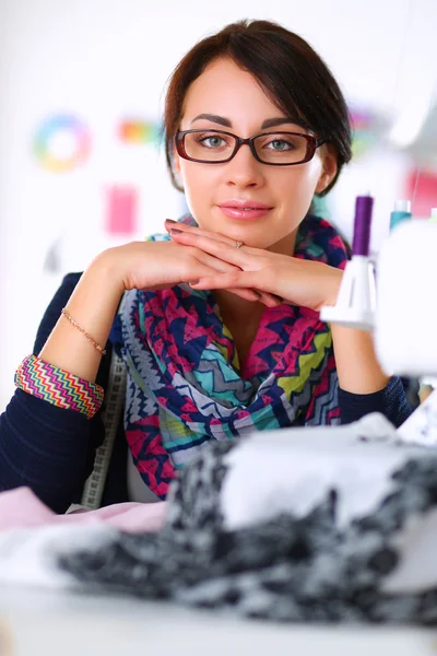 Mujer joven cosiendo sentado en su lugar de trabajo — Foto de Stock