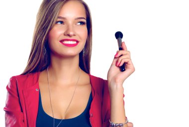 Genç güzel kadın elinde makyaj için fırça tutar