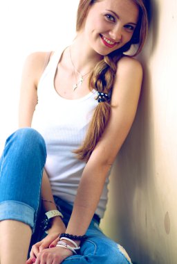 çimenlerin üzerinde kitapla oturan genç kadın