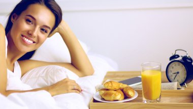 Genç ve güzel bir kadın yatakta yatıyor.