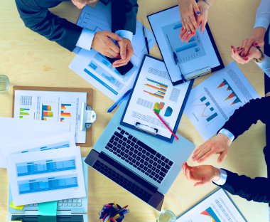 İş adamları iş toplantısında, ofiste oturup tartışıyorlar.