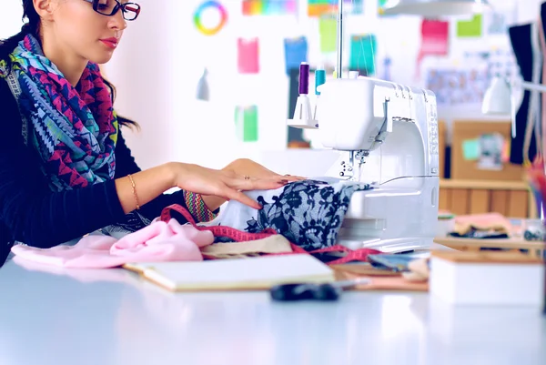 Jeune femme couture assis à son lieu de travail — Photo