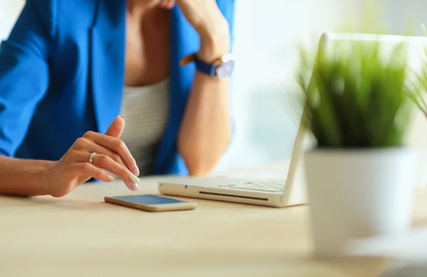 Kvinna sitter på skrivbordet med bärbar dator. — Stockfoto