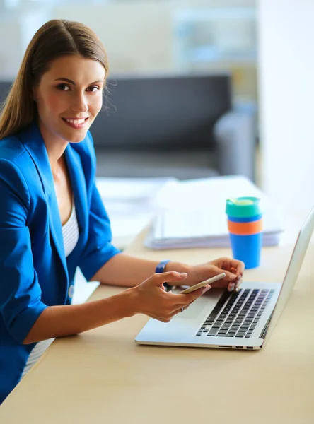 Frau sitzt mit Laptop am Schreibtisch. — Stockfoto