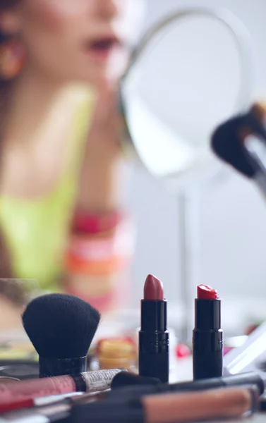 Joven hermosa mujer haciendo maquillaje cerca del espejo — Foto de Stock