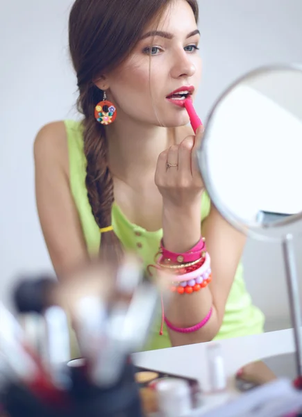 Joven hermosa mujer haciendo maquillaje cerca del espejo — Foto de Stock