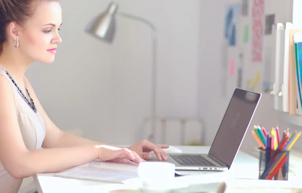 Kvinna med dokument sittande på skrivbordet och laptop — Stockfoto
