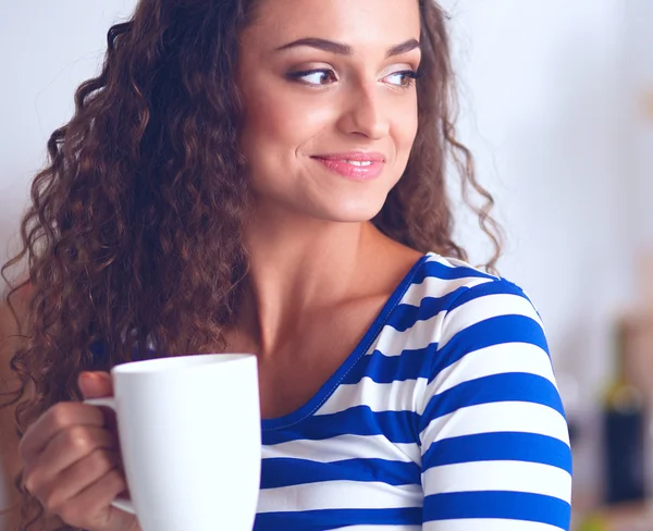 Retrato de mujer joven con taza contra fondo interior de la cocina. — Foto de Stock