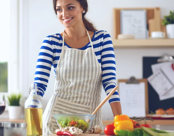 Femme souriante préparant la salade dans la cuisine — Photo