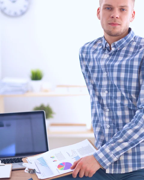 Smiling businessman with red folder sitting in the office — Stock Photo, Image