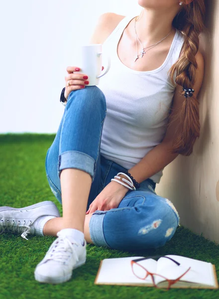 Ung kvinna sitter med boken på gräs — Stockfoto