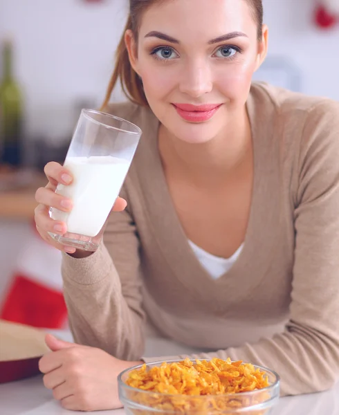 Mujer atractiva sonriente desayunando en el interior de la cocina — Foto de Stock