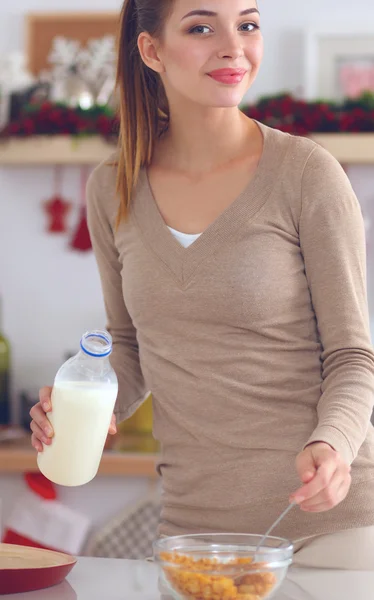 Mujer atractiva sonriente desayunando en el interior de la cocina — Foto de Stock