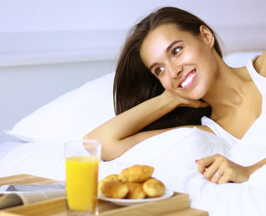 Genç ve güzel bir kadın yatakta yatıyor.