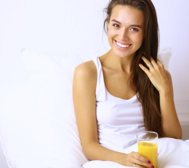 Genç ve güzel bir kadın yatakta yatıyor.