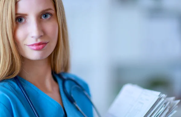 Retrato de doctora con carpeta en el pasillo del hospital —  Fotos de Stock