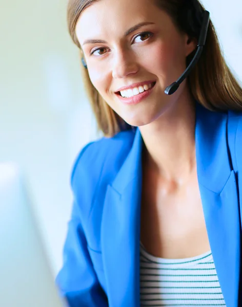 Retrato de mulher de negócios bonita trabalhando em sua mesa com fone de ouvido e laptop.. — Fotografia de Stock