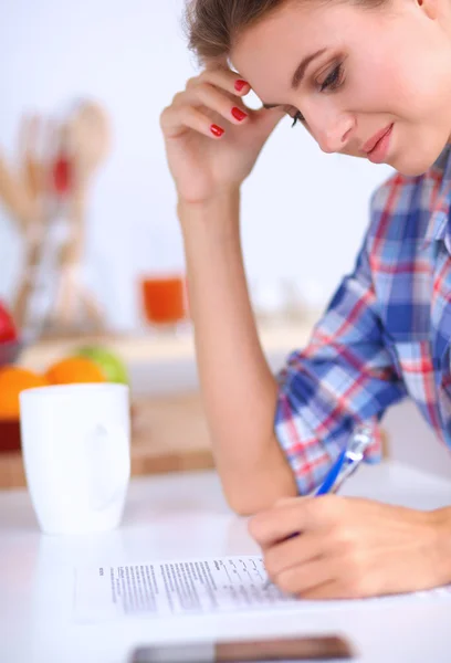 Schöne junge Frau schreibt etwas in ihren Notizblock — Stockfoto