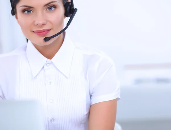 Porträt einer schönen Geschäftsfrau, die an ihrem Schreibtisch mit Headset und Laptop arbeitet — Stockfoto