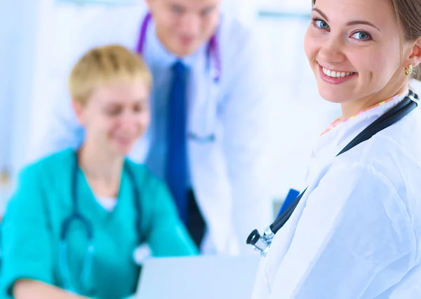 Attractive female doctor in front of medical group — Stock Photo, Image