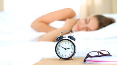 Genç bir kadın sabah alarmını erteliyor.