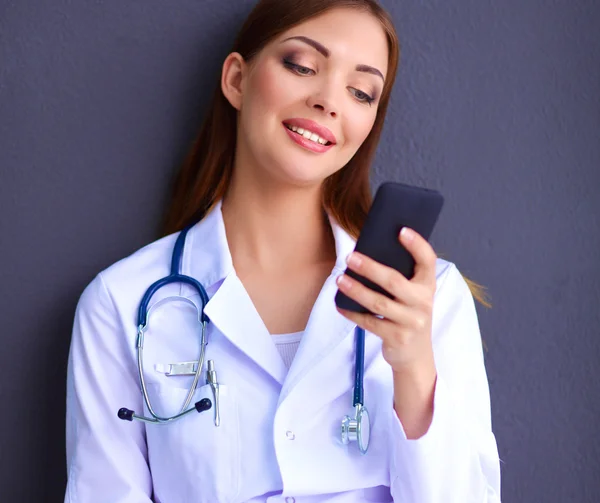 Mujer joven médico sentado con su teléfono — Foto de Stock