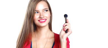 Genç güzel kadın elinde makyaj için fırça tutar