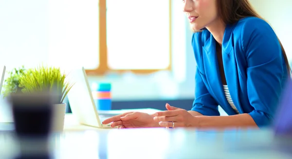 Woman sitting on the desk with laptop. — Stock Photo, Image