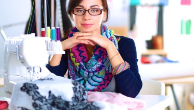 Çalışırken dikiş diken genç bir kadın.