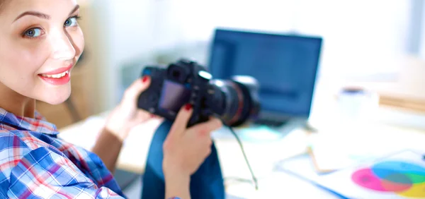 Kvinnlig fotograf sitter på skrivbordet med bärbar dator — Stockfoto