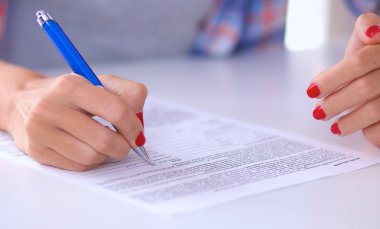Genç bir kadın not defterine bir şey yazıyor.