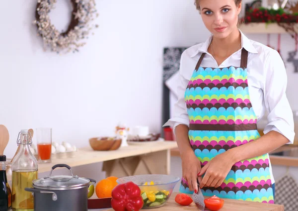 Mujer joven sonriente preparando ensalada en la cocina —  Fotos de Stock