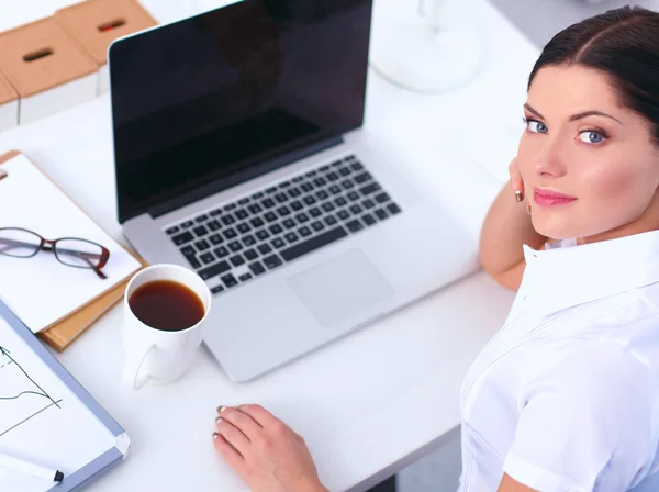 Aantrekkelijke zakenvrouw zit op het bureau in het kantoor — Stockfoto