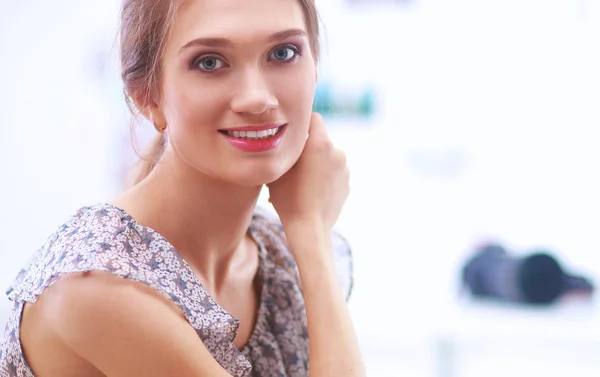 Aantrekkelijke zakenvrouw zit op het bureau in het kantoor — Stockfoto