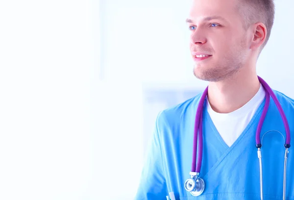 Retrato de un médico varón sonriente con portátil sentado en el escritorio en el consultorio médico — Foto de Stock