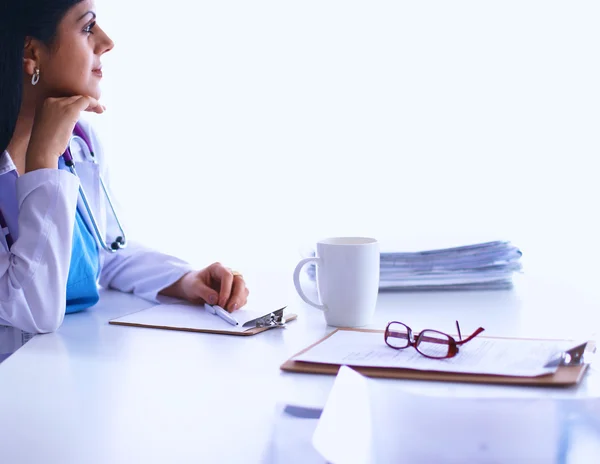 Female doctor sitting on the desk with paper  and working — Stock Photo, Image