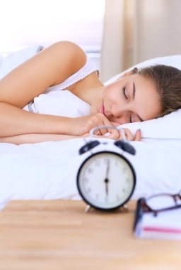 Yatakta rahat ve mutlu bir şekilde yatan güzel bir genç kadın.