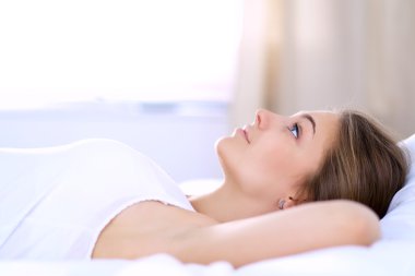 Yatakta rahat ve mutlu bir şekilde yatan güzel bir genç kadın.