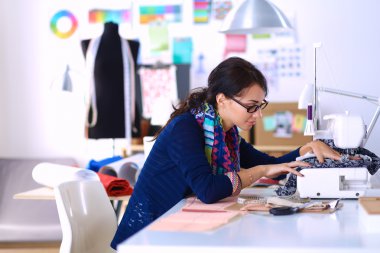 Çalışırken dikiş diken genç bir kadın.